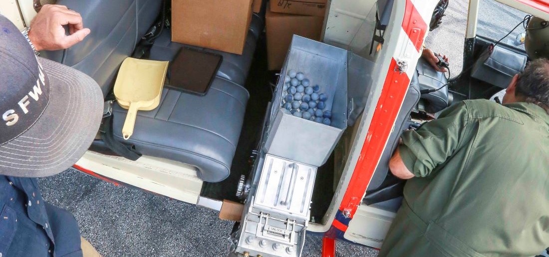 Burn Crew Loading Ignition Spheres into Helicopter