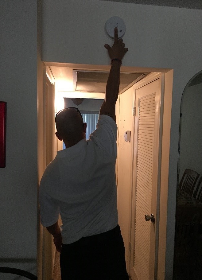 Man touching smoke alarm